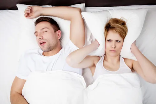 Man snoring and woman annoyed